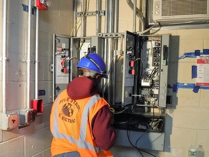 Electrician working at a control panel