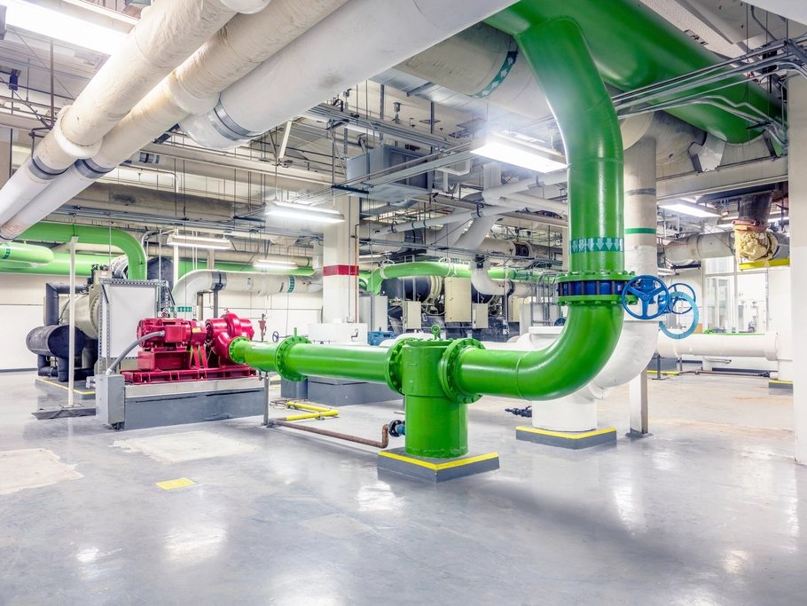 Plant room with colour-coded pipework and pumps