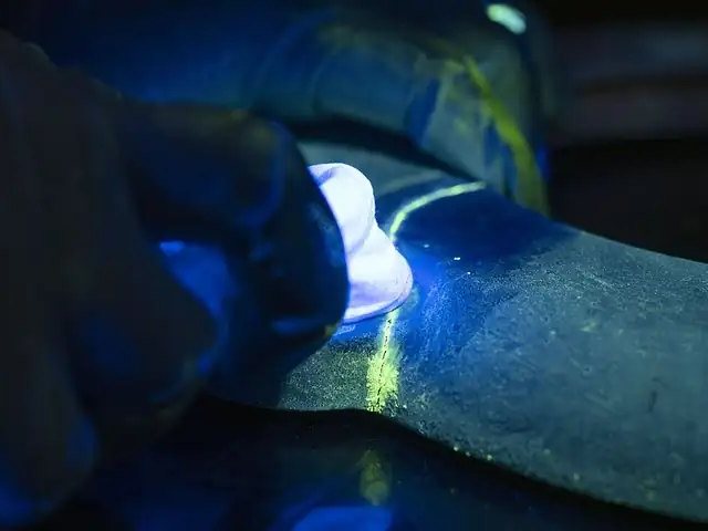 Inspector examining a component under ultraviolet light