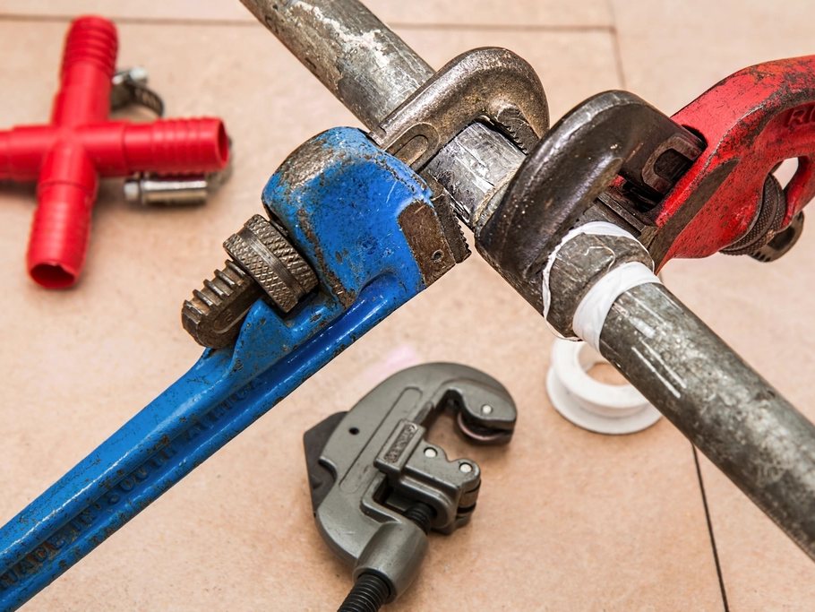 Pipe wrenches gripping a pipe fitting