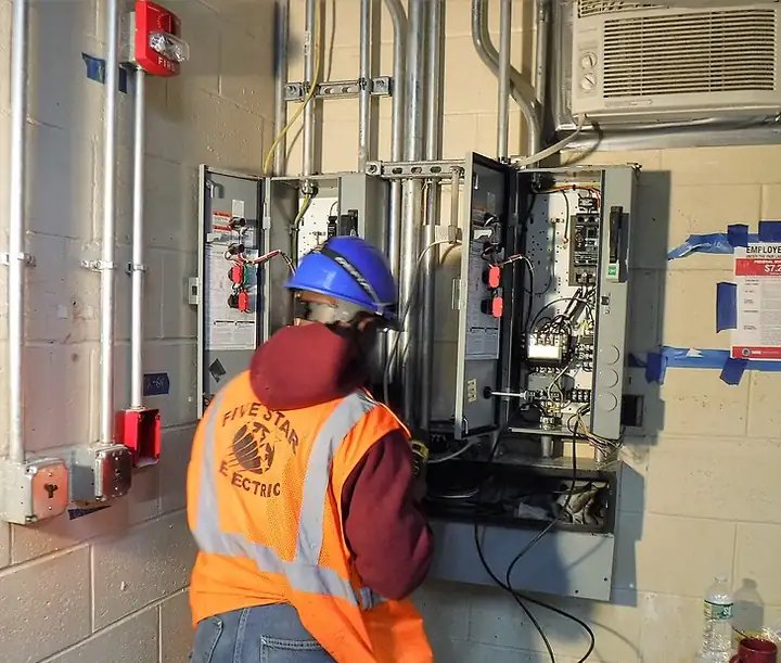 Electrician working at a control panel